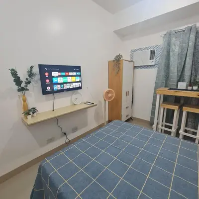 a room with a tv and a blue floor at Homely Green 2 Residences T2 in Dasmariñas