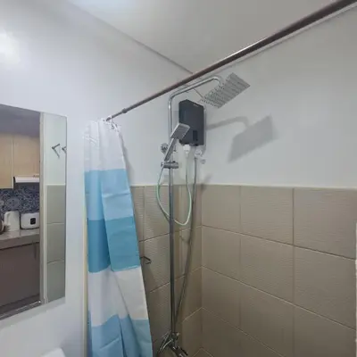 a shower in a bathroom with a shower curtain at Homely Green 2 Residences T2 in Dasmariñas