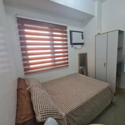 a bedroom with a bed and a large window at HOMELY @ Green 2 Residences SMDC DLSUMC in Dasmariñas