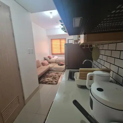 a kitchen with a couch and a living room at HOMELY @ Green 2 Residences SMDC DLSUMC in Dasmariñas