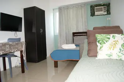 a bedroom with a bed and a desk and a television at The Beacon Makati by mvmtransient in Manila