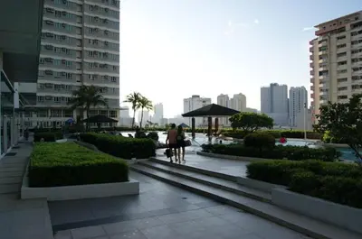 a woman walking a dog in a city with buildings at The Beacon Makati by mvmtransient in Manila
