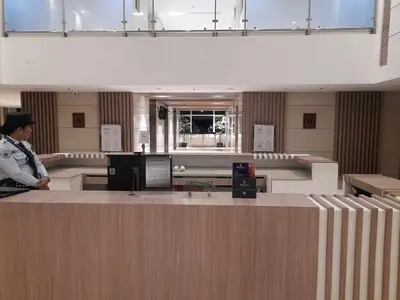 a man standing at a counter in an airport at FourSphere staycation in Manila