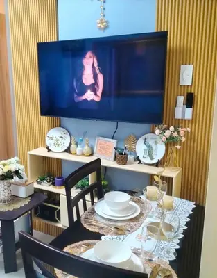 a table with plates and a television in a room at FourSphere staycation in Manila