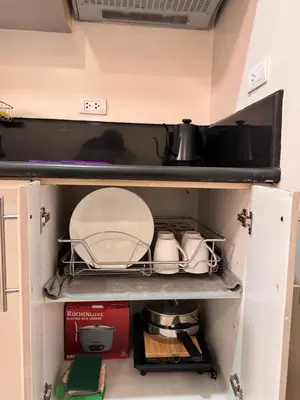 a cabinet filled with dishes and utensils at Morgan Suites Executive Residences in Manila
