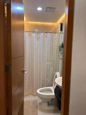 a bathroom with a toilet and a sink at Morgan Suites Executive Residences in Manila