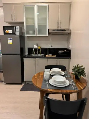 a kitchen with a wooden table with plates on it at Morgan Suites Executive Residences in Manila