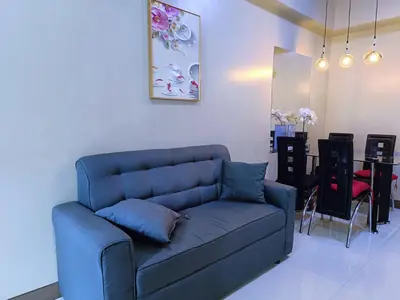 a blue couch in a living room with a table at 1BR at TWO PALMTREE VILLAS Across Manila airport terminal 3 in Manila