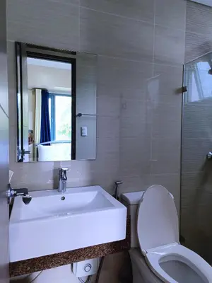 a bathroom with a sink and a toilet and a mirror at 1BR at TWO PALMTREE VILLAS Across Manila airport terminal 3 in Manila