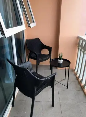 a living room with two chairs and a table at Cozy condo with balcony in Taguig in Manila