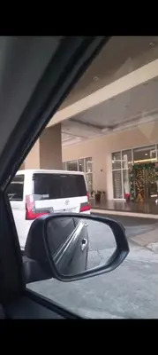 a rear view mirror of a car with a white truck at Cozy condo with balcony in Taguig in Manila
