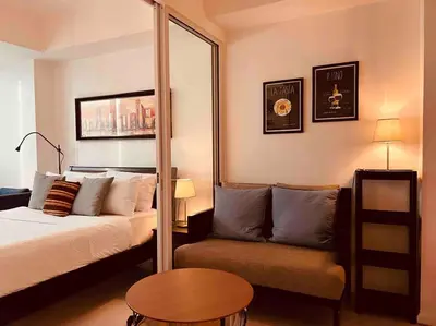 a bedroom with a bed and a couch and a mirror at Relaxing 1-Bedroom Unit in Azure Urban Resort and Residences by One Guest Place in Manila