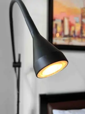 a black lamp hanging from a wall with a picture at Relaxing 1-Bedroom Unit in Azure Urban Resort and Residences by One Guest Place in Manila