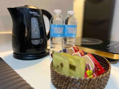 a basket of food and bottles of water on a counter at Relaxing 1-Bedroom Unit in Azure Urban Resort and Residences by One Guest Place in Manila