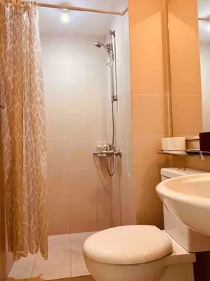 a bathroom with a shower and a toilet and a sink at Relaxing 1-Bedroom Unit in Azure Urban Resort and Residences by One Guest Place in Manila
