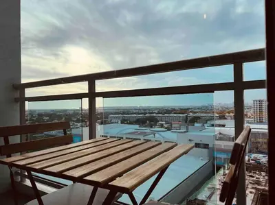 a wooden bench sitting on top of a balcony at Relaxing 1-Bedroom Unit in Azure Urban Resort and Residences by One Guest Place in Manila