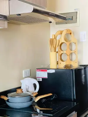 a kitchen counter with utensils on top of a microwave at Richjones Bed & Breakfast in Manila