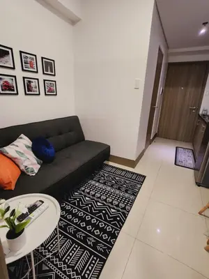 a living room with a couch and a table at Fame Residences Staycation in Manila