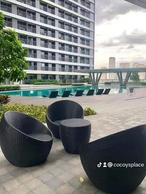a group of tables and chairs in front of a building at Fame Residences Staycation in Manila