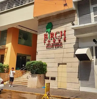 a person is standing outside of a hotel at Birch Tower in Manila