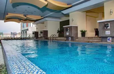 a large blue swimming pool in a hotel at Birch Tower in Manila