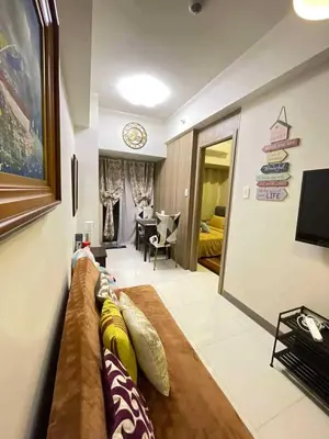 a living room with a couch with pillows on it at LJ'S Escape 1BR Coast Residences in Manila