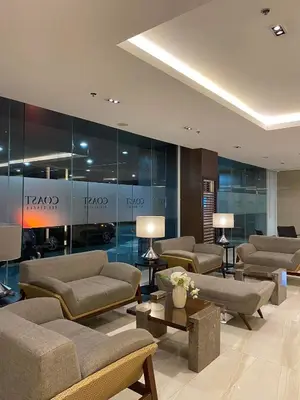 a lobby with couches and tables in a building at LJ'S Escape 1BR Coast Residences in Manila