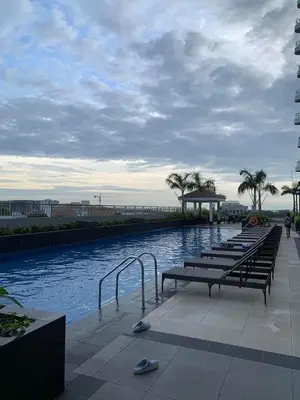 a row of benches sitting next to a body of water at LJ'S Escape 1BR Coast Residences in Manila