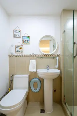 a bathroom with a toilet and a sink and a mirror at NEW 2BR of 86sqm with Parking & Netflix in BGC in Manila