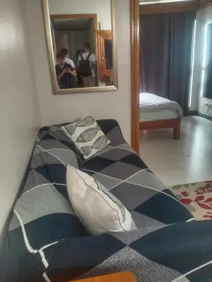 two beds in a room with a mirror at KL Rooms at Greenbelt makati with cityview in Manila