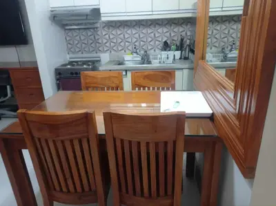 a kitchen with a wooden table and four chairs at KL Rooms at Greenbelt makati with cityview in Manila