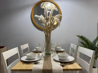 a wooden table with a vase of flowers on it at Glamorous 3BR Suite in Uptown BGC w/Bathtub in Manila