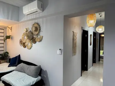 a living room with two beds and a wall at Glamorous 3BR Suite in Uptown BGC w/Bathtub in Manila
