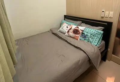 a bed with a pillow with a picture of a dog on it at Condo with Balcony at Makati SM Jazz in Manila