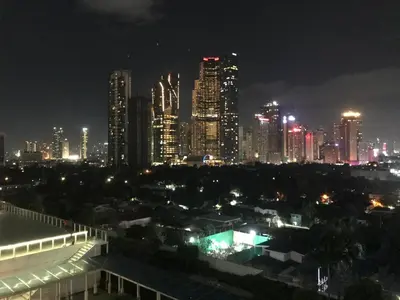 a night view of a city with tall buildings at Condo with Balcony at Makati SM Jazz in Manila