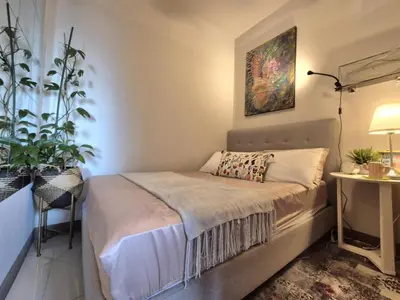 a bedroom with a bed and a painting on the wall at Cozy Comfy Suite 2BR w Balcony - Amazing Manila Bay View and City Skyline near MOA in Manila