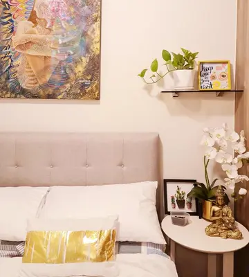 a bedroom with a bed with a table and a painting at Cozy Comfy Suite 2BR w Balcony - Amazing Manila Bay View and City Skyline near MOA in Manila