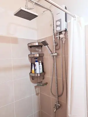 a shower with a shower head in a bathroom at Cozy Comfy Suite 2BR w Balcony - Amazing Manila Bay View and City Skyline near MOA in Manila