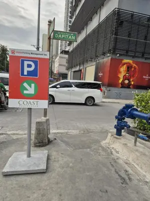 a parking sign in a parking lot with a white car at Cozy Comfy Suite 2BR w Balcony - Amazing Manila Bay View and City Skyline near MOA in Manila