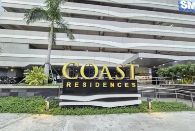 a sign in front of a building with a palm tree at Cozy Comfy Suite 2BR w Balcony - Amazing Manila Bay View and City Skyline near MOA in Manila