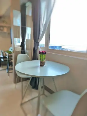 a white table with a vase of flowers on it at Cozy Comfy Suite 2BR w Balcony - Amazing Manila Bay View and City Skyline near MOA in Manila
