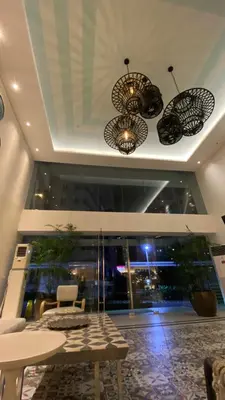 a lobby with two chandeliers and a table and chairs at Azure Urban Beach Resort Residences in Manila