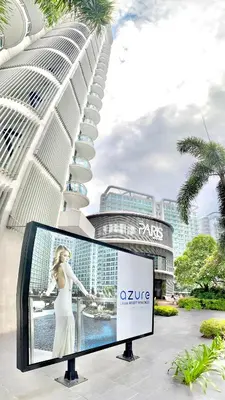 a billboard in front of a building with a picture of a woman at Azure Urban Beach Resort Residences in Manila
