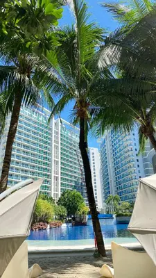 a view of a resort with palm trees and a pool at Azure Urban Beach Resort Residences in Manila