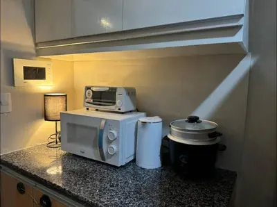 a kitchen with a microwave on a counter at Modish 1BR One Uptown BGC direct to Uptown Mall in Manila