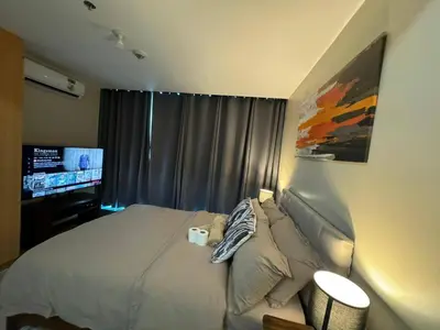 a bedroom with a bed and a flat screen tv at Modish 1BR One Uptown BGC direct to Uptown Mall in Manila