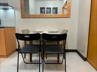 a dining room table with two chairs and a mirror at Modish 1BR One Uptown BGC direct to Uptown Mall in Manila