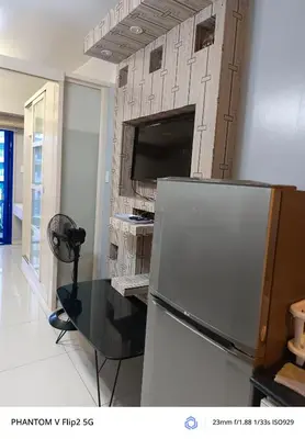 a living room with a refrigerator and a tv at Sea Residence Finest in Manila