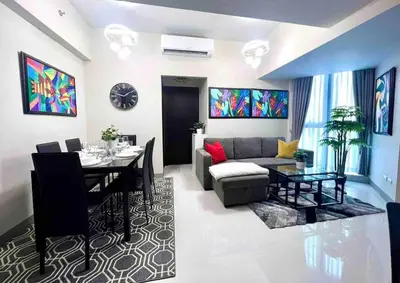 a living room with a couch and a dining room at Cozy 2 Bedrooms in BGC with Balcony Bathtub 600Mbps in Manila