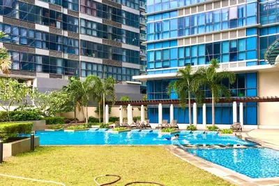 a swimming pool in front of a tall building at Cozy 2 Bedrooms in BGC with Balcony Bathtub 600Mbps in Manila